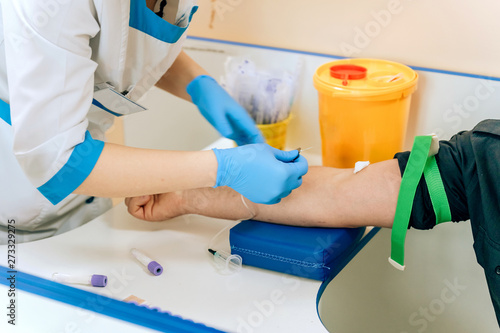 Biochemical analysis of blood in men. HIV test for a young guy. A blood sample from a vein for the test. The man in the doctor's office photo