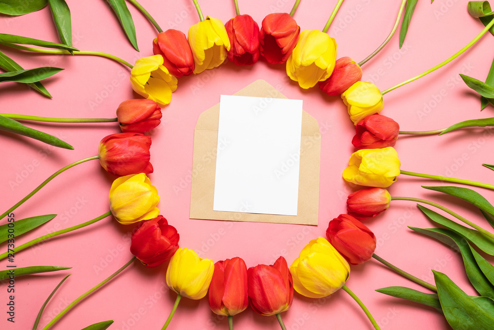 Top view of minimalistic card mockup with red tulips on a red background. Flat lay with copy space. Top view of minimalistic card mockup with red tulips on a red background. Flat lay with copy space.