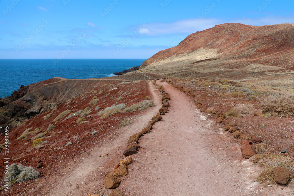 Montana Roja (Red mountain) path in volcanic area with red rocks and soil, ground lava field, El Medano, Tenerife