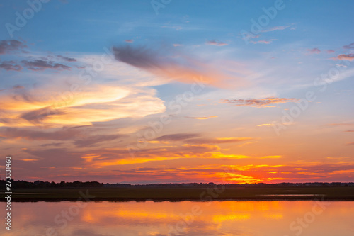 Fototapeta Naklejka Na Ścianę i Meble -  Sunset reflection lagoon. beautiful sunset behind the clouds and blue sky above the over lagoon landscape background. dramatic sky with cloud at sunset