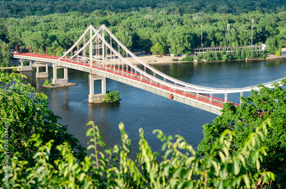 View of pedestrian Park bridge over the Dnipro river. Summertime View of pedestrian Park bridge over the Dnipro river. Summertime
