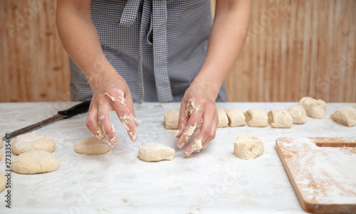 The hostess cuts the dough in the kitchen © schankz