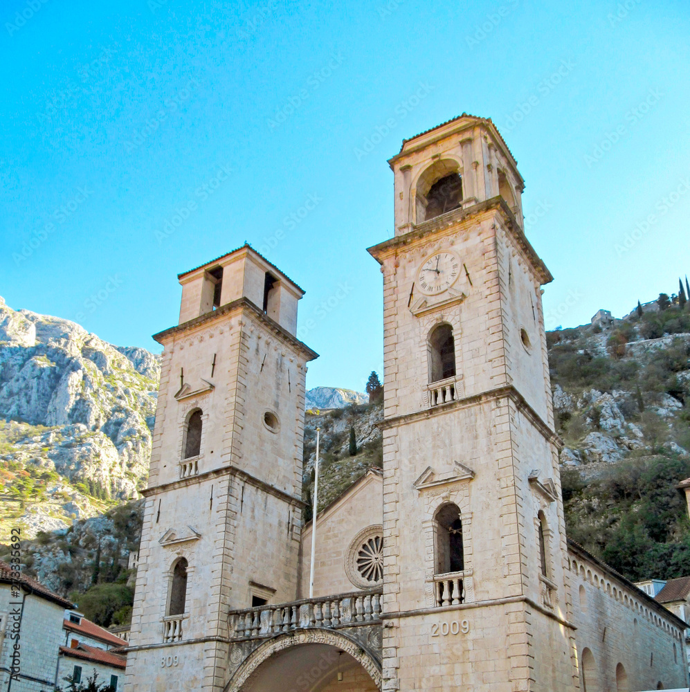 Old architecture of Kotor, Montenegro, Europe. Beautiful view of ancient city with blue sky and green trees on a summer sunny day.