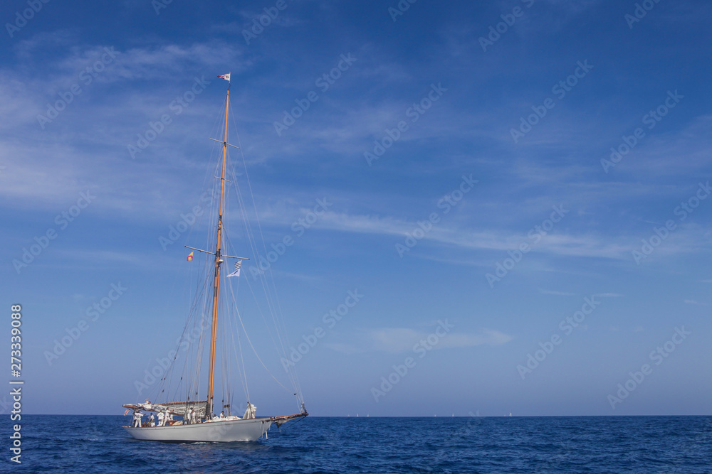 Nautical sports in the ocean. Vintage yachts race in Barcelona. Old ships and boats in the sea. Regatta in mediterranean sea. Sails, mast, sheet, canvas in the sky. Holidays in spain. 