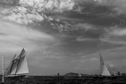 Vintage yachts race in Barcelona. Old ships and boats in the sea. Black and white photos of nautical sports in the ocean. Regatta in mediterranean sea. Sails, mast, sheet, canvas in the sky. Holidays