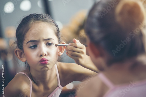 Beautiful girl  a ballet dancer Looking at the mirror and lipstick makeup behind the stage before starting acting