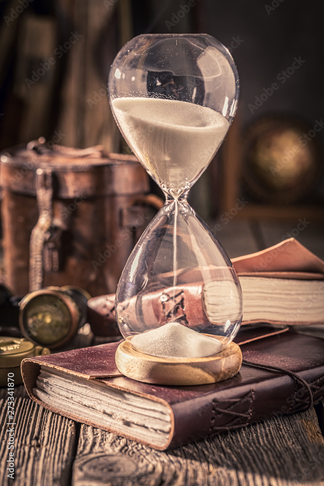 Hourglass and journal as a concept of travel memories Hourglass and journal as a concept of travel memories