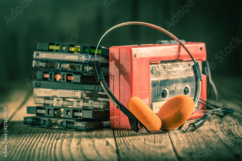 Φωτογραφία Closeup of cassette tape, red walkman and headphones