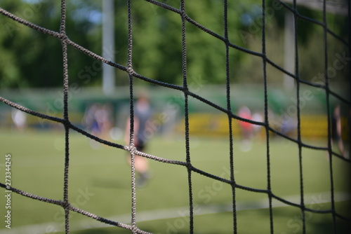 Grid of a football goal with a blurred view of a football field