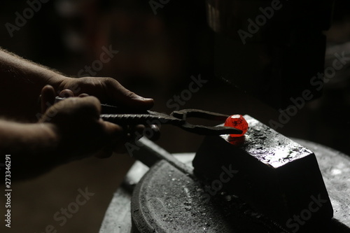 The blacksmith works with incandescent iron © viktoria_koks