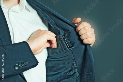 Business man pulls out or put his leather wallet into jacket pocket