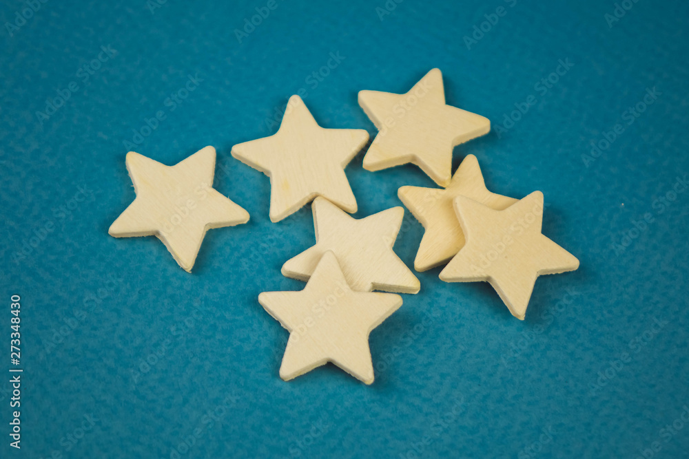 A bunch of wooden stars on a blue background chaotically scattered. A bunch of wooden stars on a blue background chaotically scattered.