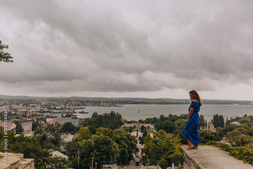 Beautiful tanned girl in long blue dress