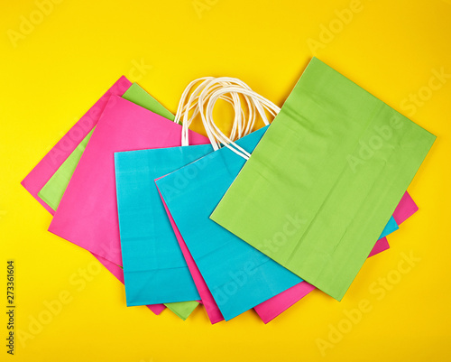 rectangular multi-colored paper shopping bags with white handles