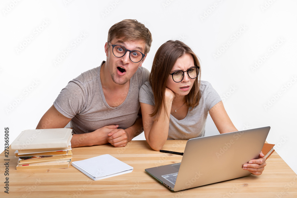 Nerds, study, people concept - a couple of people look at the laptop and look like surprised