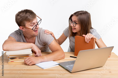 Education and student concept - a funny couple doing exercises or homework with laptop