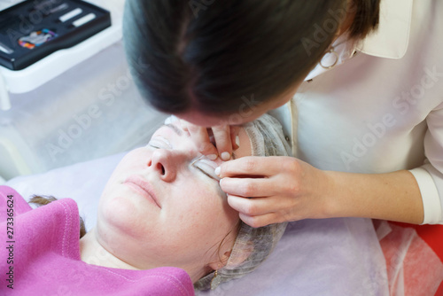 Woman on the procedure for eyelash extensions, eyelashes lamination