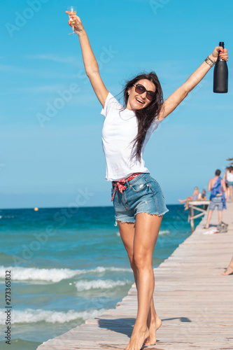 girl on the pier by the sea with alcohol in his hands