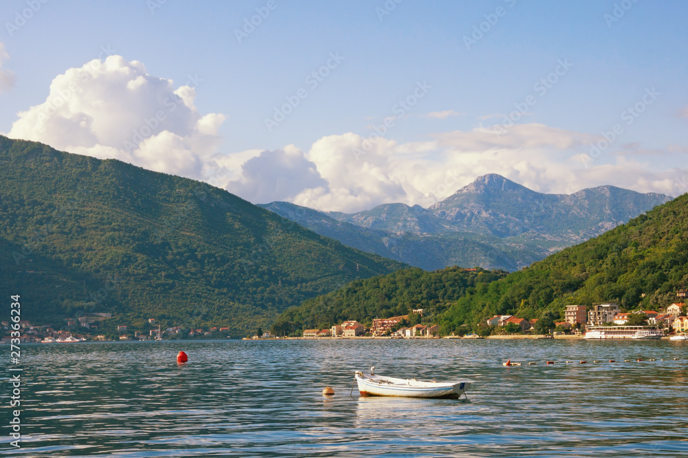 Beautiful  Mediterranean landscape  on sunny summer day - mountains, sea and fishing boat on the water.  Montenegro, Adriatic Sea, Bay of Kotor