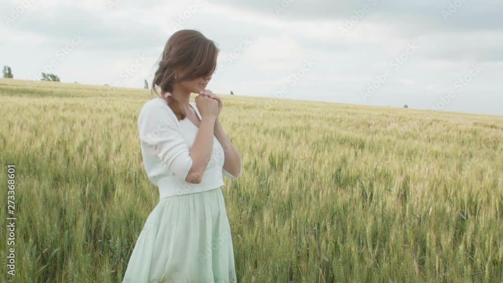 a young girl praying in a wheat field, a woman among ears of corn enjoying nature and thanking God, a concept of religion and faith a young girl praying in a wheat field, a woman among ears of corn enjoying nature and thanking God, a concept of religion and faith