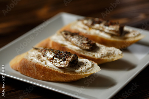 toast with sardines on a wood background closeup. top view