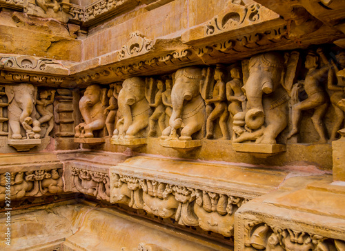 Stone carved erotic scene with elephants in Kahjuraho ancient temple, India photo