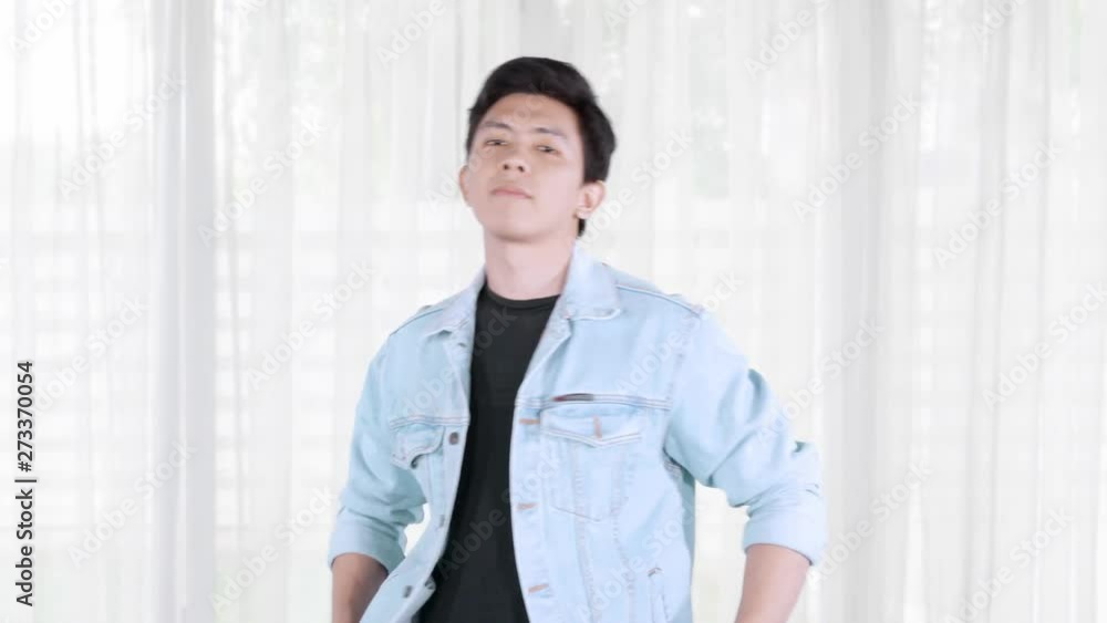 Handsome man with casual clothes posing in the living room at home. Shot in 4k resolution Handsome man with casual clothes posing in the living room at home. Shot in 4k resolution