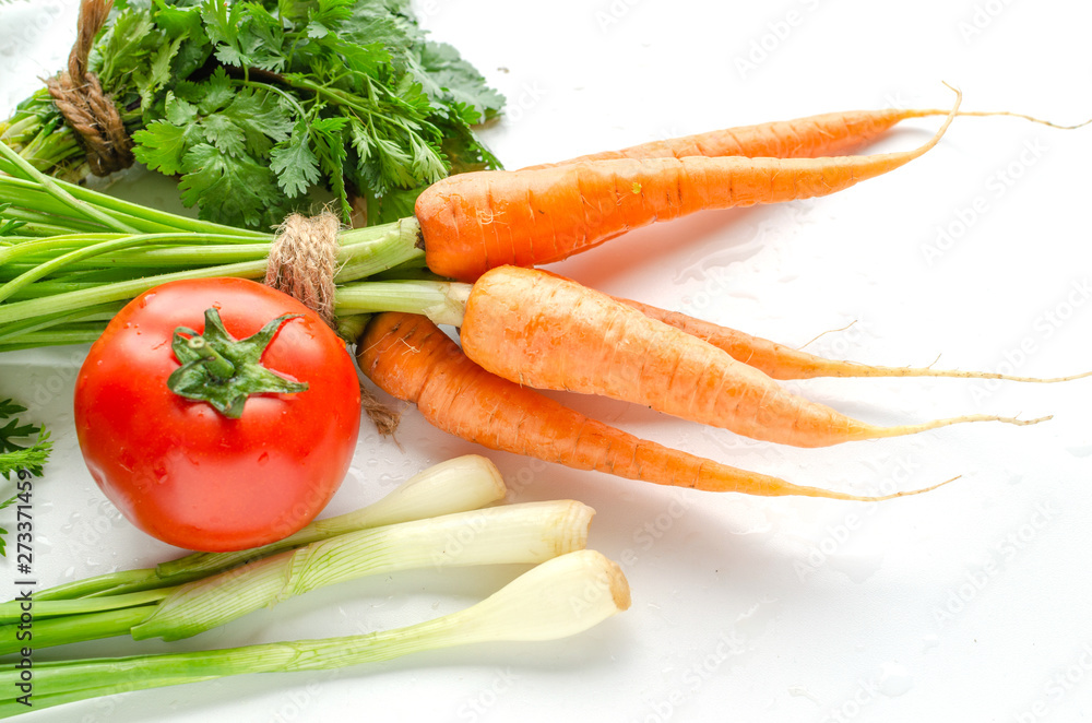 Fresh carrot with green leaves, tomato, onion and parsley on white background. Fresh carrot with green leaves, tomato, onion and parsley on white background.