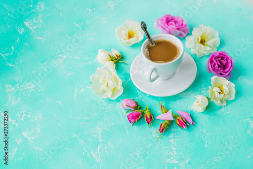 Mug of coffee and bouquet of roses flowers on pastel background. Top view, overheat. Flat lay style composition, Round frame wreath made of beige rose flowers and morning coffee.Copy space