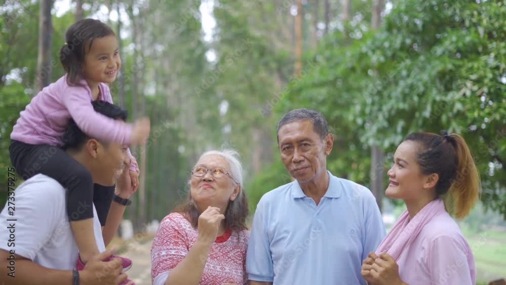 Three generation family standing at the park while talking together. Shot in 4k resolution Three generation family standing at the park while talking together. Shot in 4k resolution