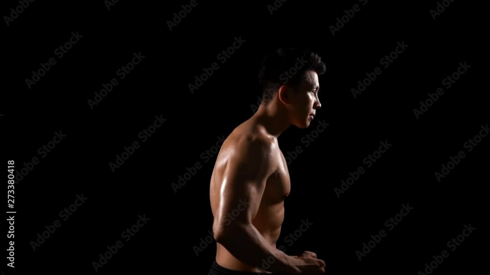Slow motion of handsome muscular man doing workout by running in place. Shot in the studio on dark background Slow motion of handsome muscular man doing workout by running in place. Shot in the studio on dark background