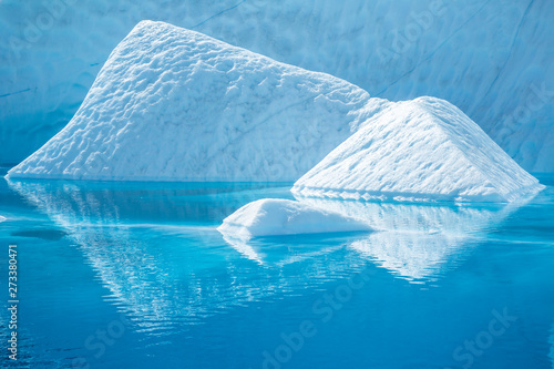 Icebergs reflected in deep blue water. photo