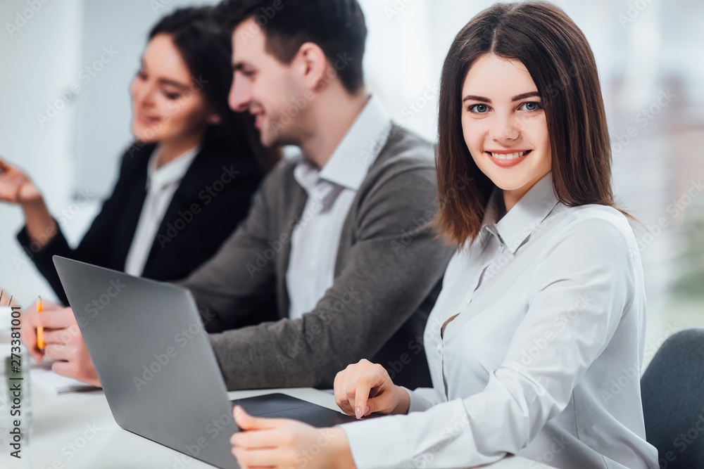 Successful female using laptop on her work in office, while posing to the camera.. Successful female using laptop on her work in office, while posing to the camera..
