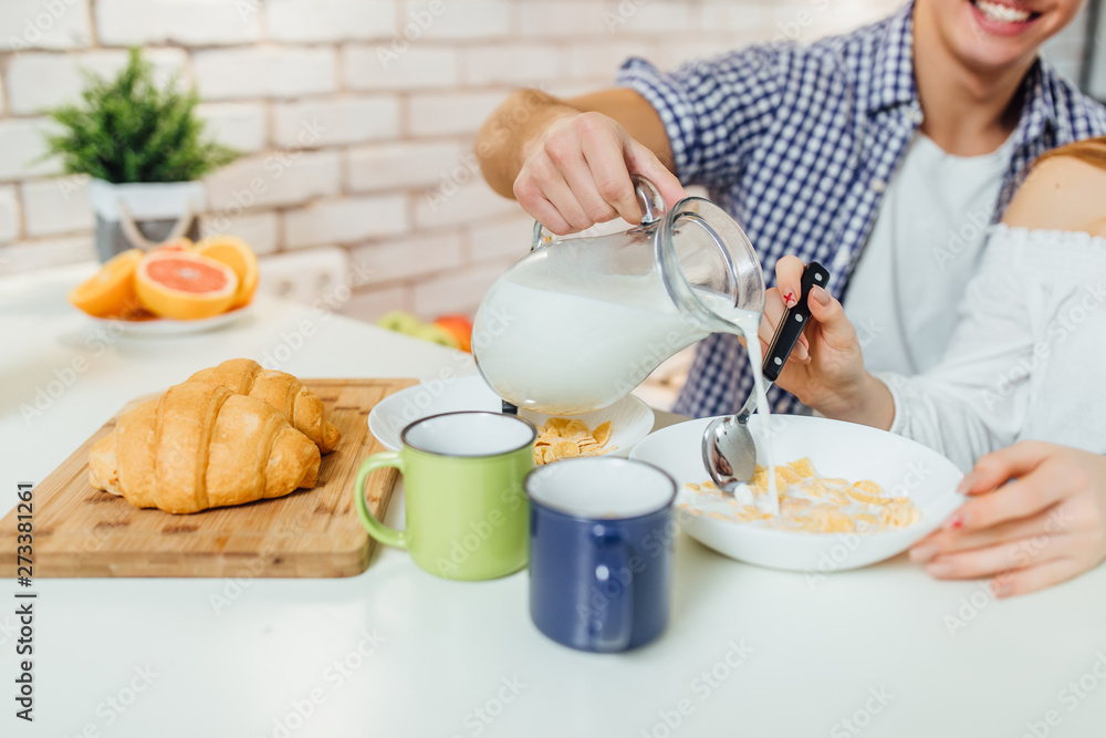 Close up photo of morning desk with cereal, milk,and croissant,healthy food. Man holding milk.. Close up photo of morning desk with cereal, milk,and croissant,healthy food. Man holding milk..