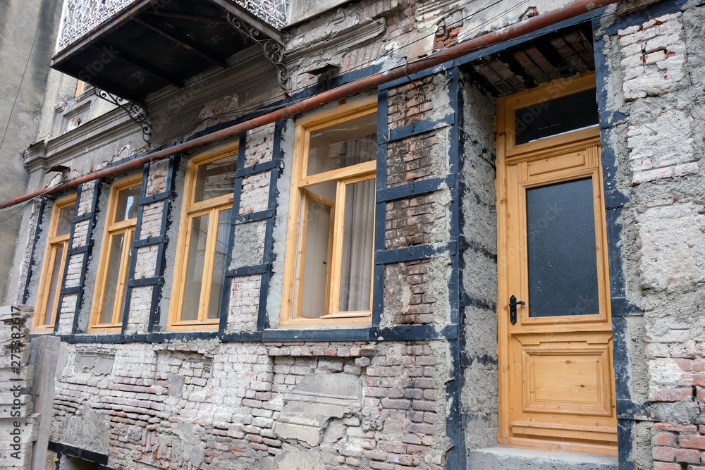 The building is in the process of reconstruction of the view from the street. Wooden door and windows, brick walls and metal supports The building is in the process of reconstruction of the view from the street. Wooden door and windows, brick walls and metal supports
