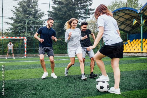 Training and football match between youth soccer teams. Young boys with woman playing soccer game. Competition between players running kicking soccer ball.
