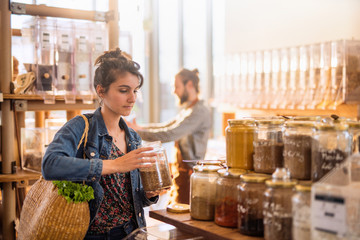 Beautiful young woman shopping in a bulk food store