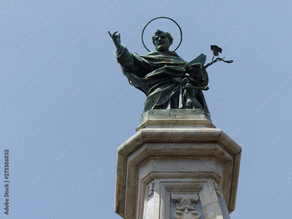 Statua di bronzo di San Domenico all'estremità di un obelisco a Napoli in Italia.