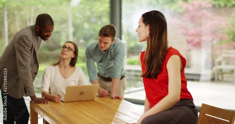 4K Middle Eastern businesswoman smiling at camera with team working in background. Successful small business concept. Slow motion. 4K Middle Eastern businesswoman smiling at camera with team working in background. Successful small business concept. Slow motion.