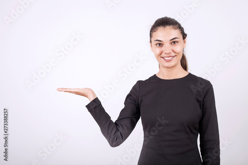 beautiful young businesswoman standing with crossed arms and smiling at camera in office