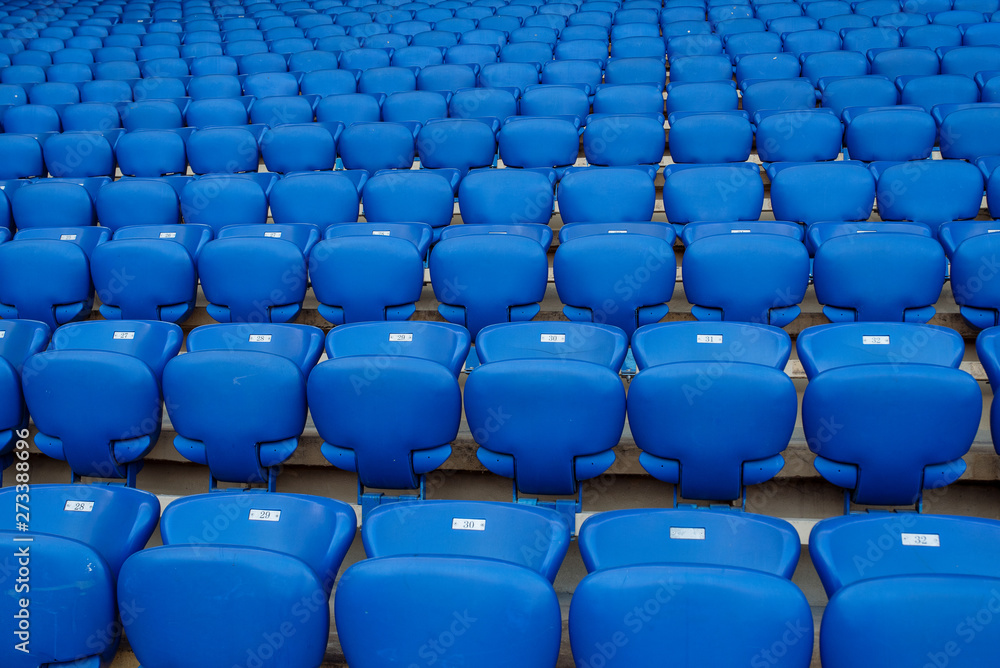 Rows of blue seats in the stand in the sports arena Rows of blue seats in the stand in the sports arena