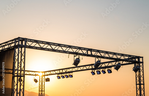 rock stage iron beams and stage lights against the setting sun. sunset. concert. heat