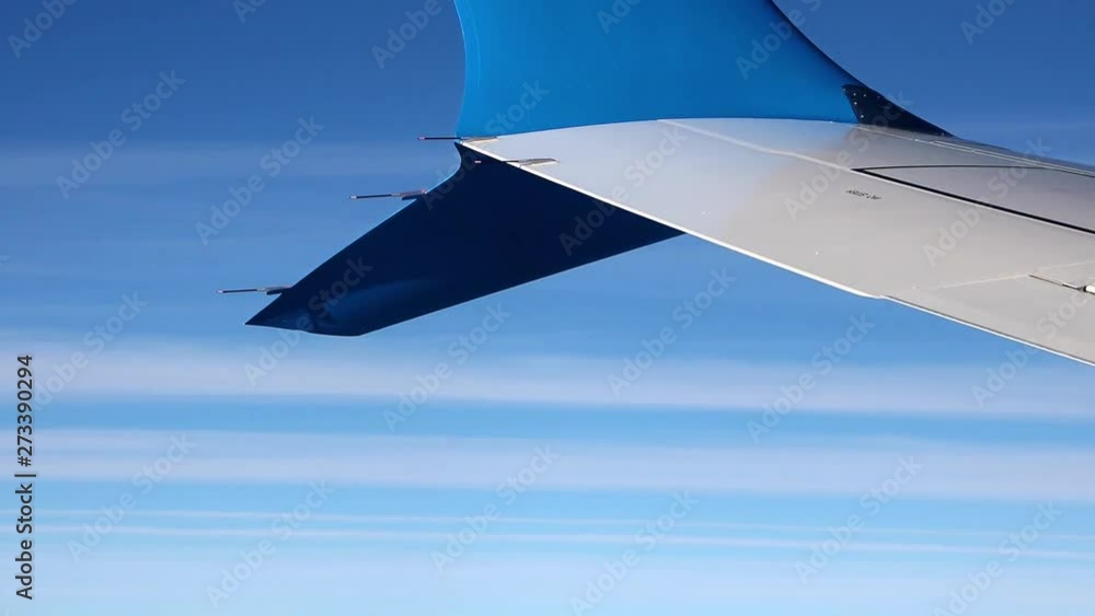 The blue winglet on a wing of plane when a flight in a blue sky. Part ...