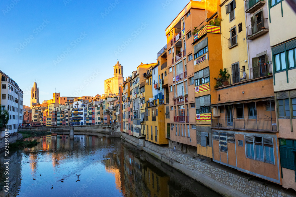 Colorful yellow and orange houses reflected in water, Girona