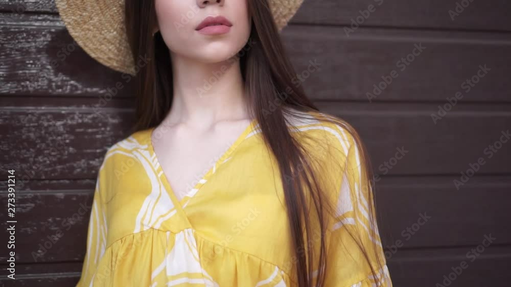 Beautiful girl model posing on the background of brown wall in summer yellow dress. Beautiful girl model posing on the background of brown wall in summer yellow dress.
