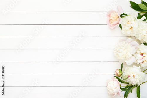White peonies on wooden background. Copy space, top view.