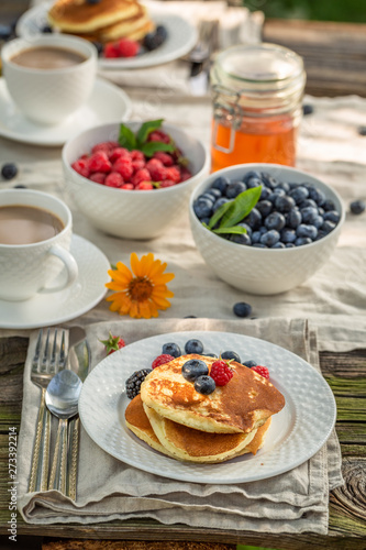 Homemade pancakes served with coffee in summer garden