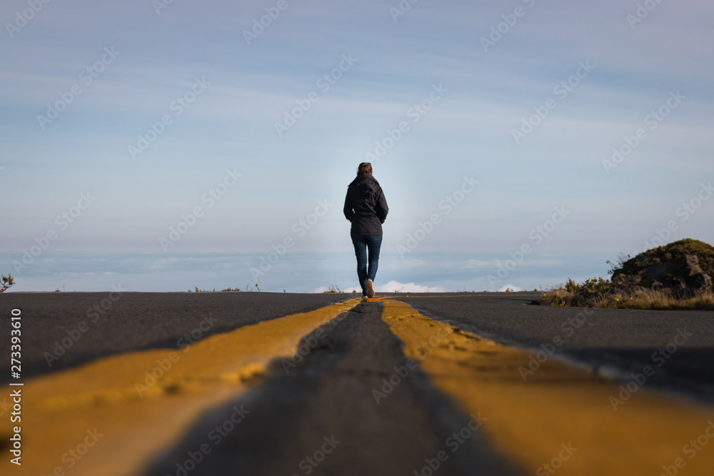 Woman walking on the line down the street above the clouds - obrazy, fototapety, plakaty 