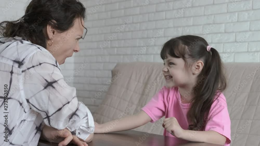 A woman plays with a child. Mother and daughter are fighting in their arms. A woman plays with a child. Mother and daughter are fighting in their arms.