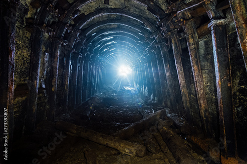 Dark abandoned coal mine with rusty lining in backlight © Mulderphoto